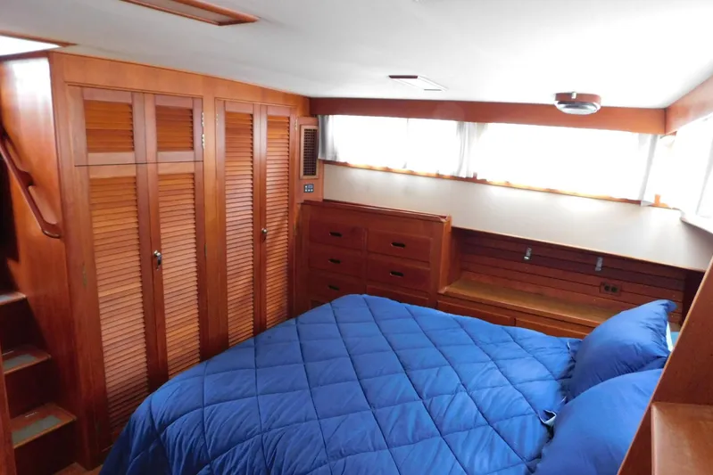 Susan Gail Yacht Photos Pics Cozy bedroom in 1986 Grand Banks 46 Classic yacht with wood paneling and blue bedding.