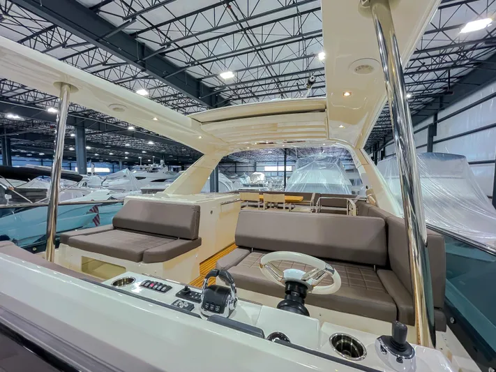 Total Package Yacht Photos Pics 2016 Prestige 680 Flybridge yacht interior with seating and helm in a showroom.