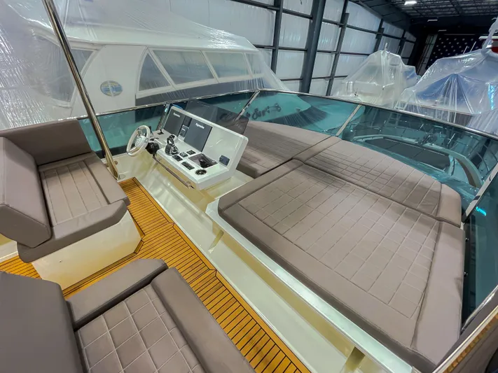 Total Package Yacht Photos Pics Prestige 680 Flybridge 2016 interior with seating and control panel in a covered storage area.