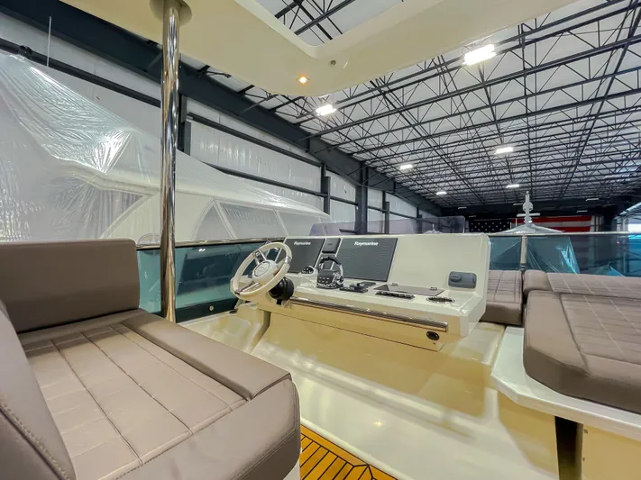 Total Package Yacht Photos Pics Flybridge of 2016 Prestige 680 yacht with modern controls and seating in a spacious indoor setting.