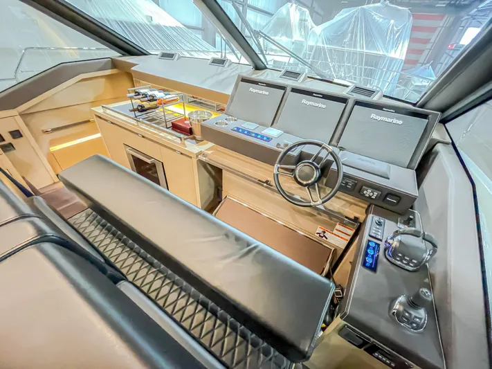 Total Package Yacht Photos Pics Helm of 2016 Prestige 680 Flybridge yacht with advanced navigation systems and luxurious seating.