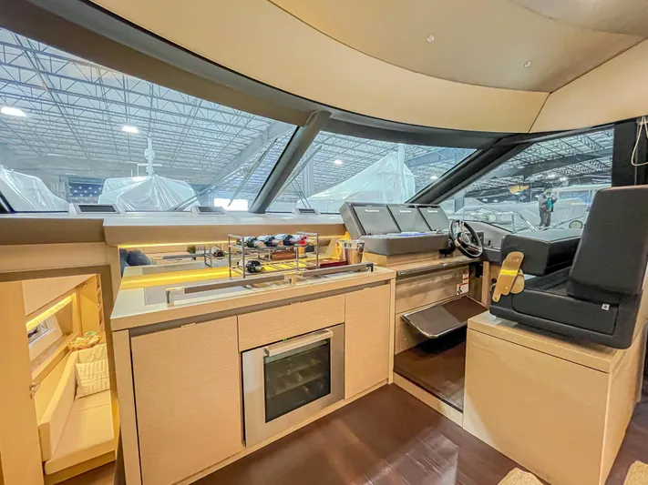 Total Package Yacht Photos Pics Interior of 2016 Prestige 680 Flybridge yacht with modern helm and kitchenette.