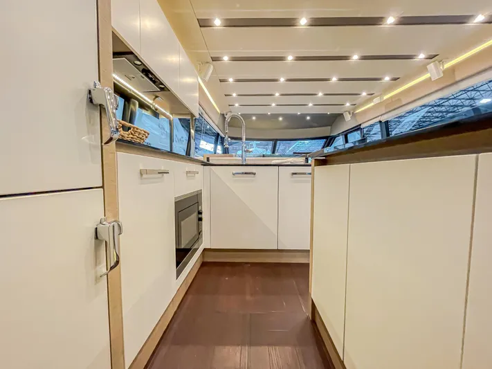 Total Package Yacht Photos Pics Luxurious kitchen interior of 2016 Prestige 680 Flybridge yacht with modern design and lighting.