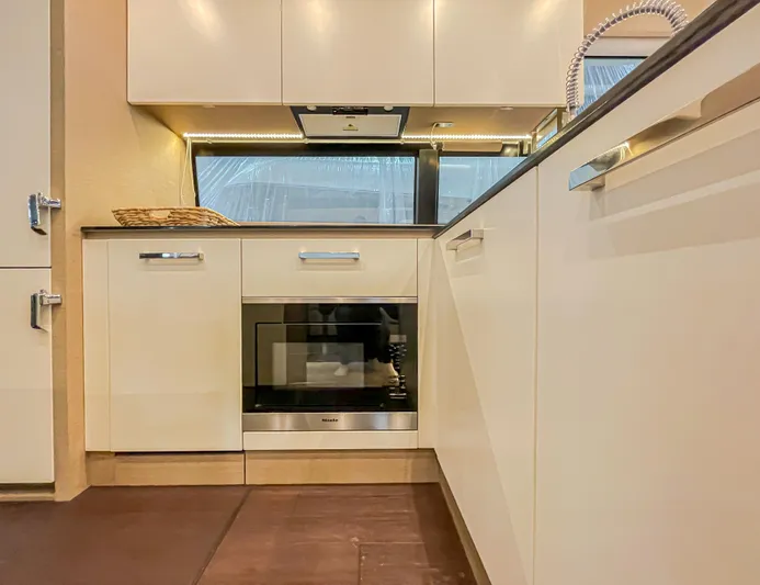 Total Package Yacht Photos Pics Modern kitchen interior of 2016 Prestige 680 Flybridge yacht, featuring sleek cabinetry and built-in appliances.