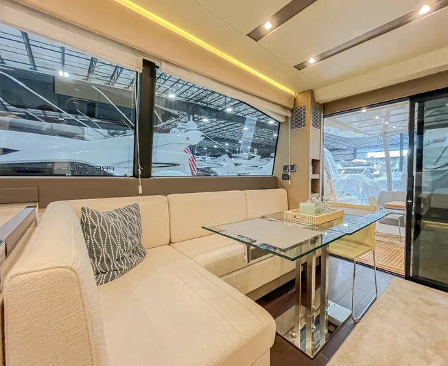 Total Package Yacht Photos Pics Luxurious interior of 2016 Prestige 680 Flybridge yacht with elegant seating and glass table.