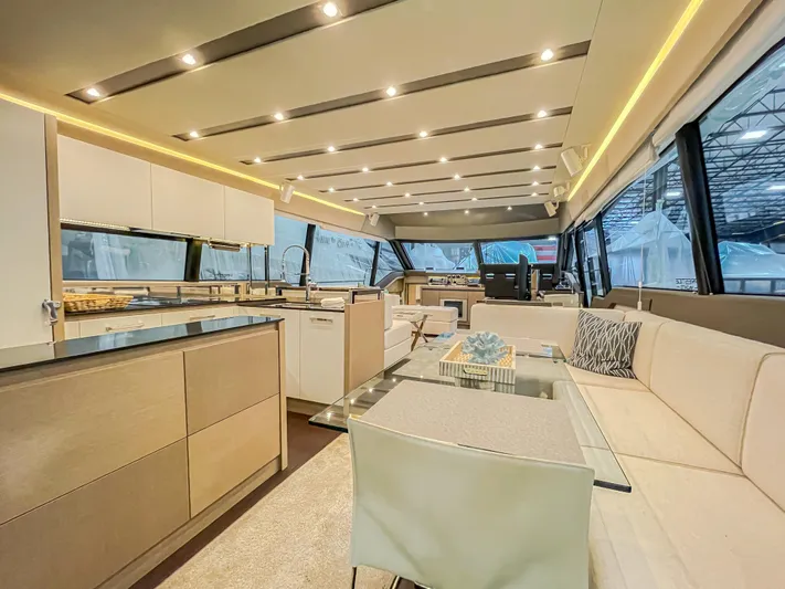 Total Package Yacht Photos Pics Luxurious interior of 2016 Prestige 680 Flybridge yacht with modern kitchen and seating area.