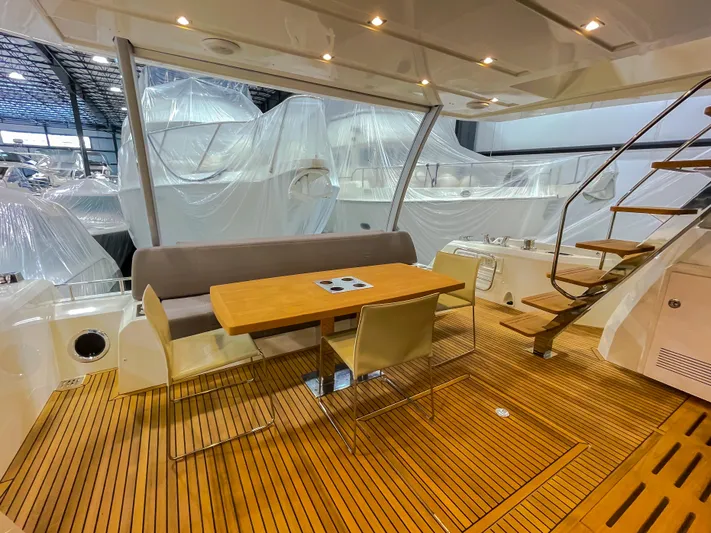 Total Package Yacht Photos Pics Prestige 680 Flybridge 2016 yacht interior with wooden deck and seating area.