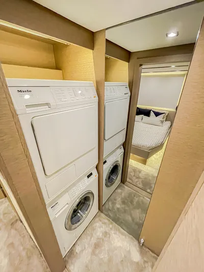 Total Package Yacht Photos Pics Laundry area with stacked washer and dryer in 2016 Prestige 680 Flybridge yacht.