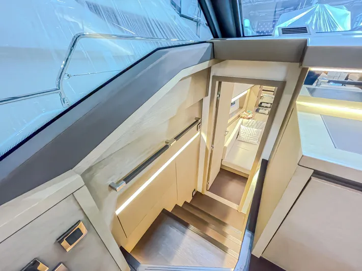 Total Package Yacht Photos Pics Interior staircase of 2016 Prestige 680 Flybridge yacht, featuring modern design and ambient lighting.
