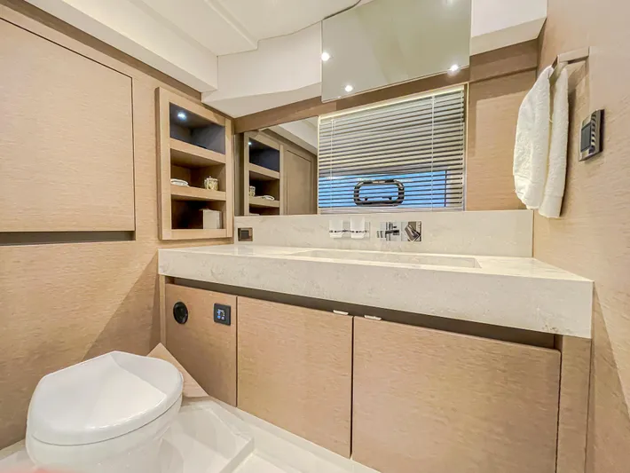 Total Package Yacht Photos Pics Luxurious bathroom in 2016 Prestige 680 Flybridge yacht with modern fixtures and wooden cabinetry.