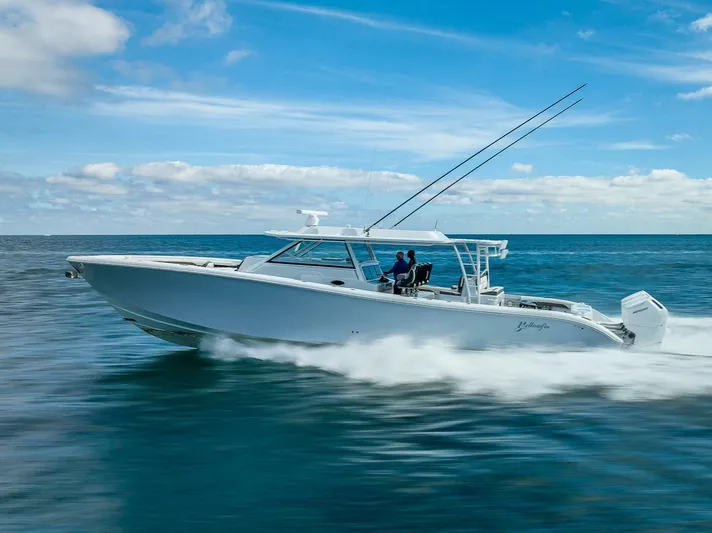 54 Offshore Yacht Photos Pics 2024 Yellowfin 54 Offshore boat cruising on open water under a clear blue sky.