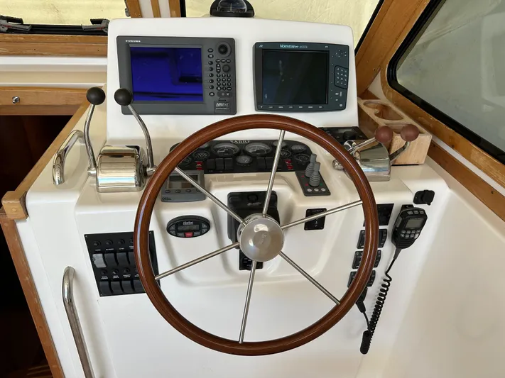 Bay Saddle Yacht Photos Pics 2005 Sabre 38 Hardtop Express helm with steering wheel and navigation controls.