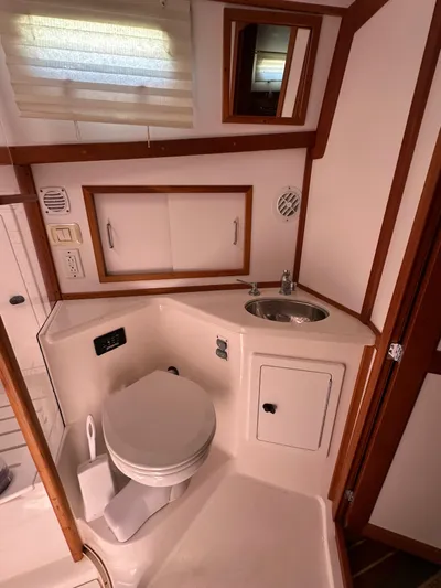 Bay Saddle Yacht Photos Pics 2005 Sabre 38 Hardtop Express bathroom with sink, toilet, and storage cabinets.