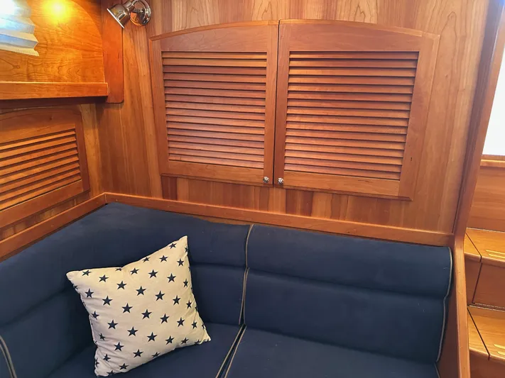 Bay Saddle Yacht Photos Pics Interior of 2005 Sabre 38 Hardtop Express with wooden paneling and blue cushioned seating.