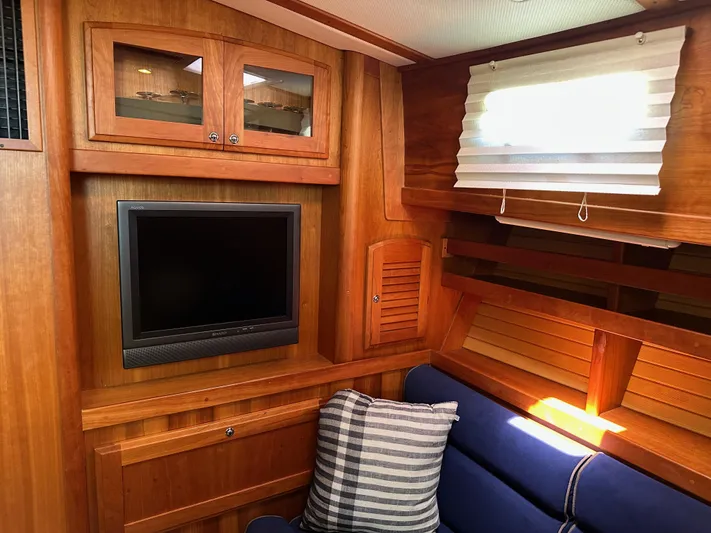 Bay Saddle Yacht Photos Pics Interior of 2005 Sabre 38 Hardtop Express with wood paneling, TV, and blue seating.