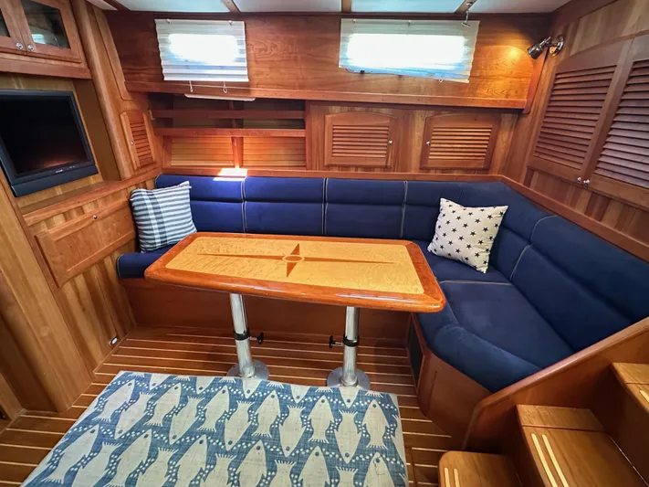 Bay Saddle Yacht Photos Pics Interior of 2005 Sabre 38 Hardtop Express with blue seating and wooden table.
