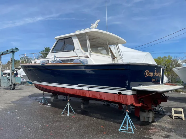 Bay Saddle Yacht Photos Pics 2005 Sabre 38 Hardtop Express boat on stands, blue hull, red bottom, outdoor setting.