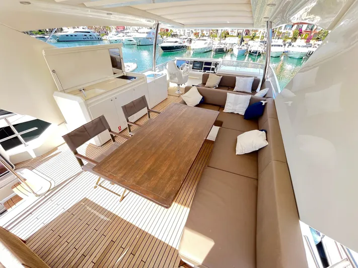 Princess Of The Seas Yacht Photos Pics Luxurious Jeanneau Prestige 750 yacht deck with seating, table, and marina view, 2017 model.