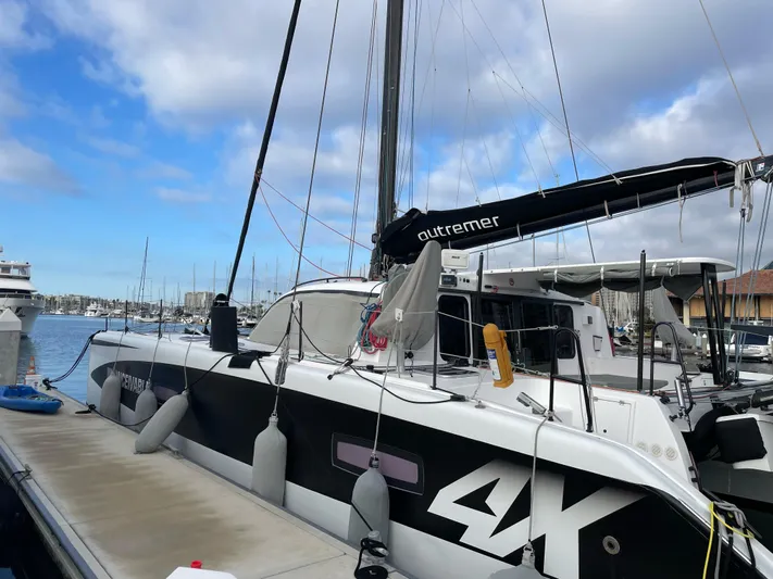 Inconceivable Yacht Photos Pics 2018 Outremer 4X catamaran docked at marina under cloudy sky.