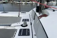 2018 Outremer 4X catamaran deck with netting and ropes, docked in a marina.