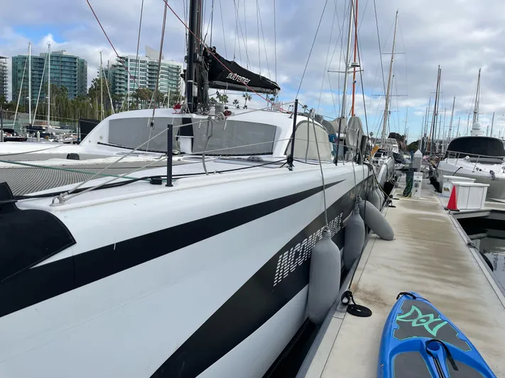 Inconceivable Yacht Photos Pics 2018 Outremer 4X catamaran docked at marina with paddleboard nearby.