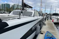 2018 Outremer 4X catamaran docked at marina with paddleboard nearby.