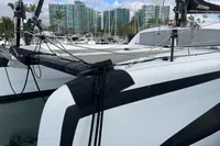 Outremer 4X 2018 catamaran docked in marina with modern buildings in background.