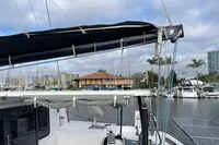 2018 Outremer 4X catamaran docked in a marina with solar panels and cityscape background.