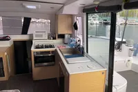 Interior of 2018 Outremer 4X catamaran with modern kitchen and marina view.