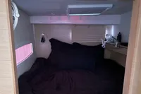 Cozy cabin interior of 2018 Outremer 4X with black bedding and reading lights.