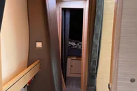 Interior hallway of 2018 Outremer 4X yacht, featuring wooden paneling and cozy cabin entrance.