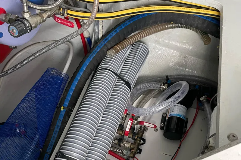 Inconceivable Yacht Photos Pics Engine compartment of a 2018 Outremer 4X, featuring hoses and mechanical components.