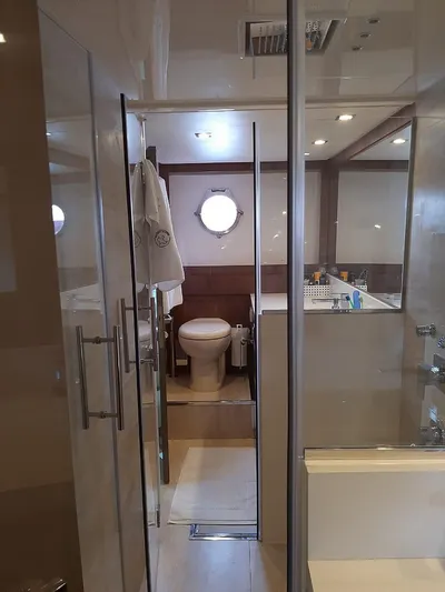  Yacht Photos Pics Luxury yacht bathroom with modern fixtures, glass shower, and porthole window on Intermarine 80, 2020 model.