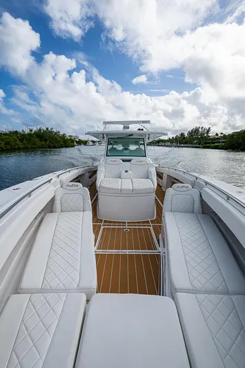  Yacht Photos Pics Luxurious 2022 HCB 53 boat with white seating and wooden deck on a sunny day.