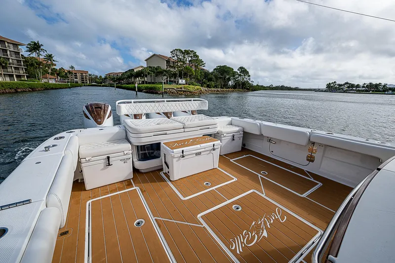  Yacht Photos Pics Luxurious 2022 HCB 53 boat deck with seating, on a scenic waterfront.