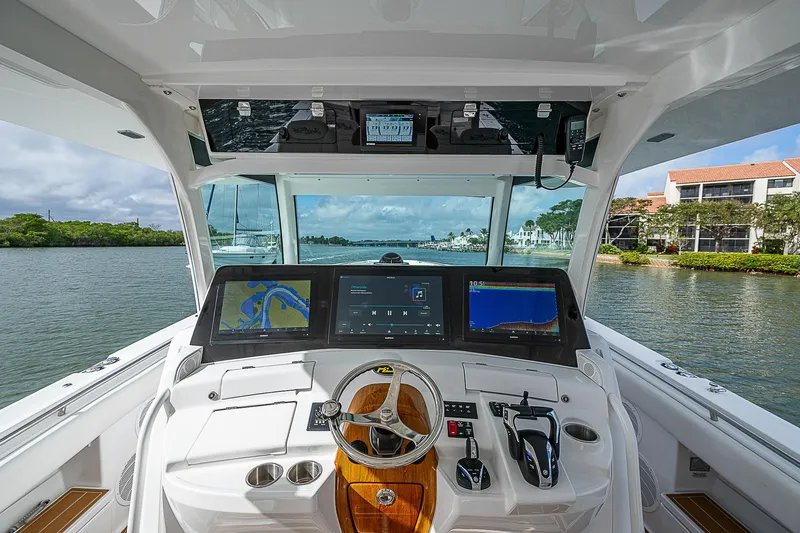  Yacht Photos Pics 2022 HCB 53 boat helm with advanced navigation screens and controls on a scenic waterway.