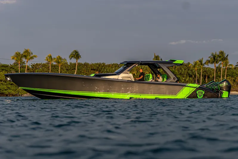 Yacht Photos Pics 2024 Adrenaline Reaper boat on water, sleek design, vibrant green accents, tropical background.