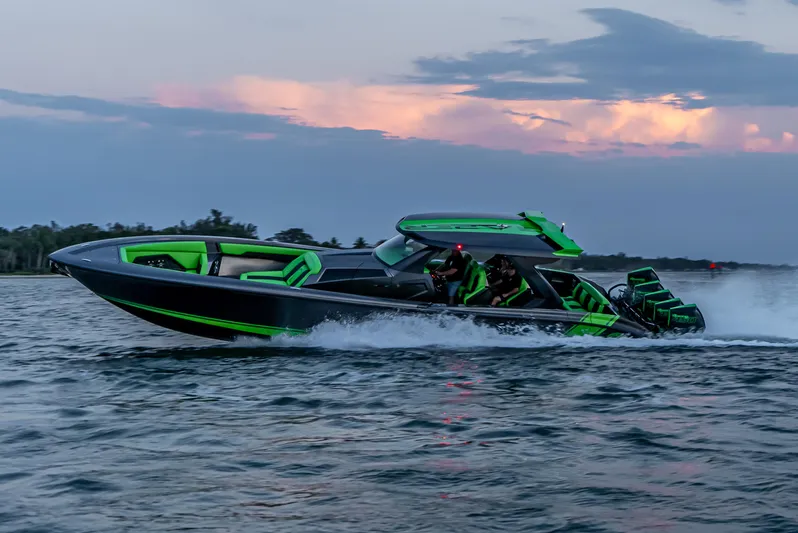  Yacht Photos Pics 2024 Adrenaline Reaper speedboat cruising on water at sunset, featuring sleek design and vibrant colors.