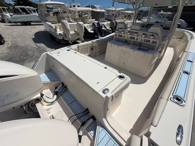 336-311 Brokerage Ron Yacht Photos Pics 2018 Grady-White Canyon 336 boat interior with seating and storage, docked among other boats.