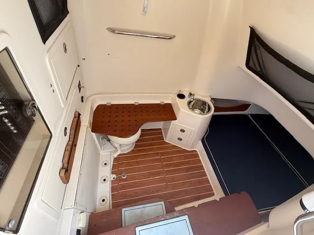 336-311 Brokerage Ron Yacht Photos Pics 2018 Grady-White Canyon 336 boat interior with wooden flooring and compact amenities.