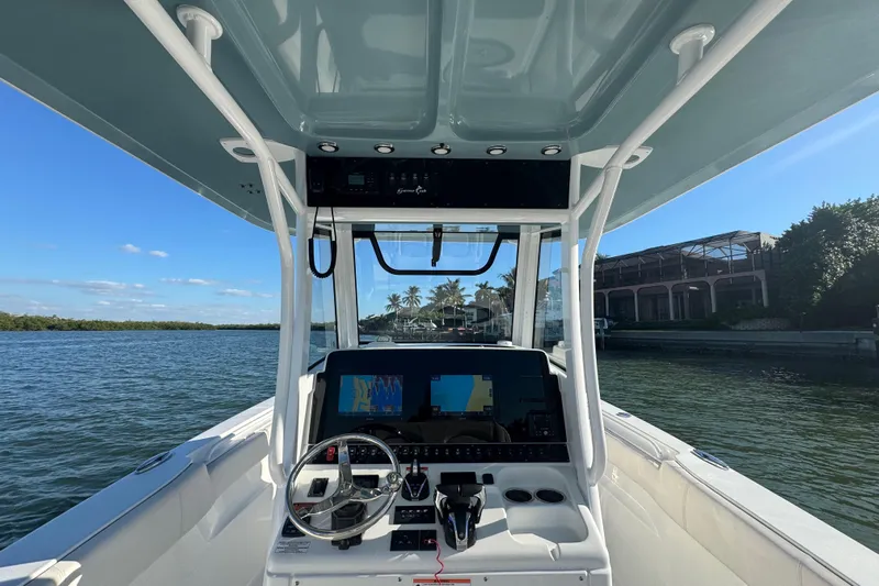  Yacht Photos Pics 2021 Sea Hunt Gamefish 30 boat console with navigation screens, steering wheel, and waterfront view.