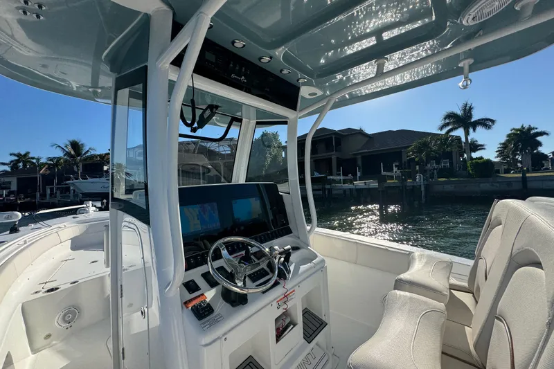  Yacht Photos Pics 2021 Sea Hunt Gamefish 30 boat interior with forward seating, docked near waterfront homes.