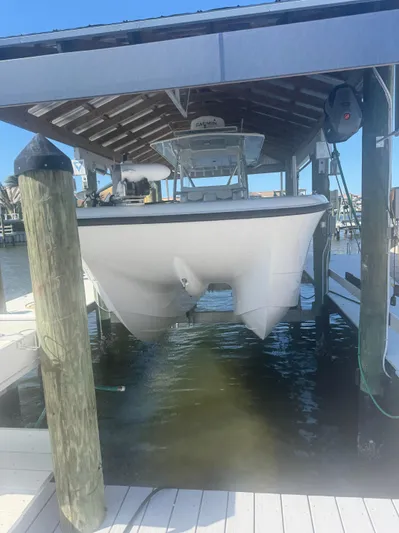  Yacht Photos Pics 2023 Invincible 33 Catamaran docked under a covered boat lift.