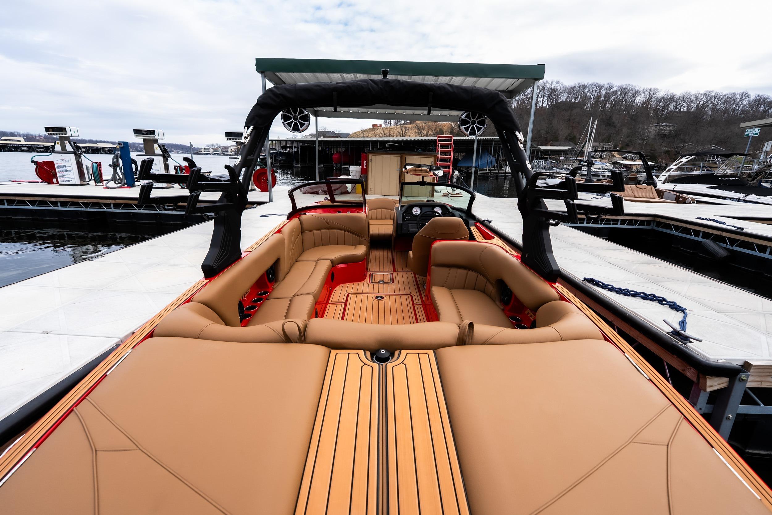2026 MB B52 23 Classic boat with luxurious tan seating at a marina.