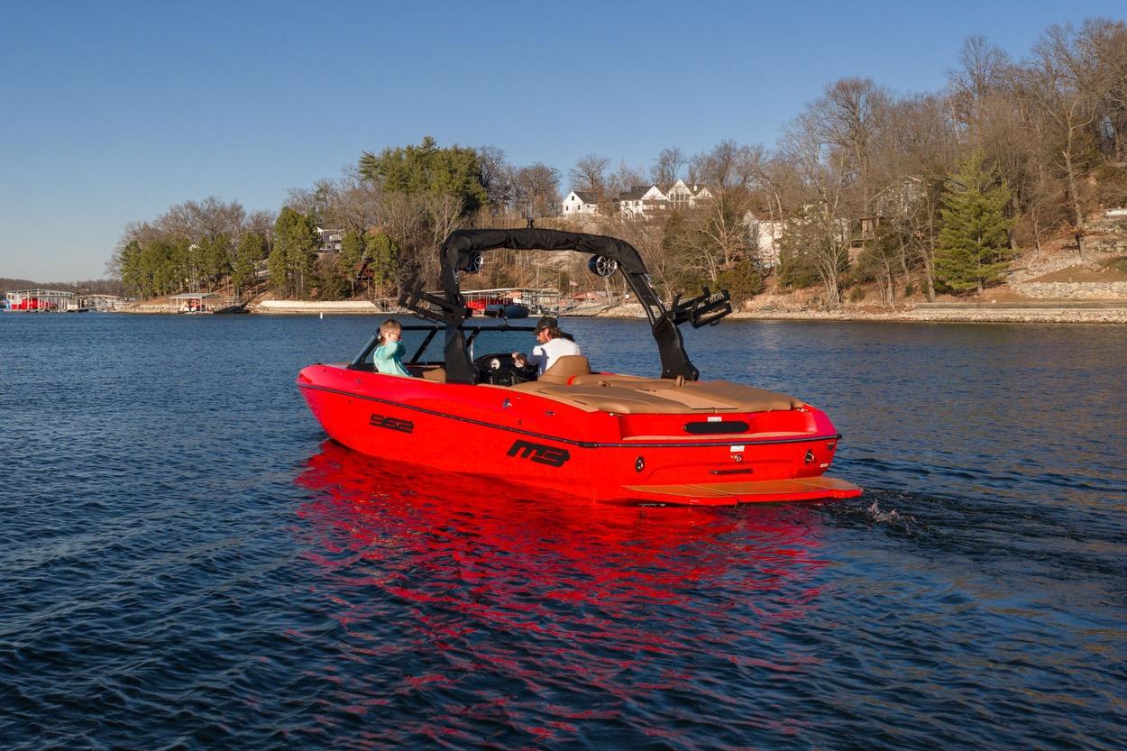 Red 2026 MB B52 23 Classic boat cruising on a scenic lake.