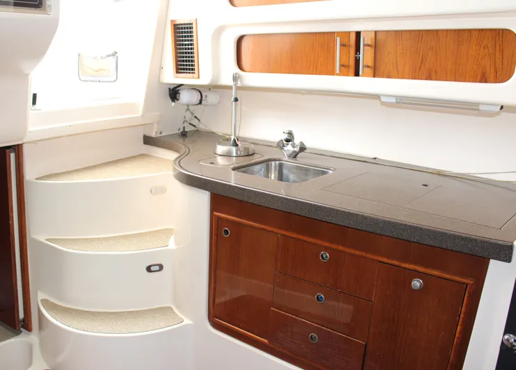  Yacht Photos Pics 2007 Grady-White 360 Express boat interior kitchen with sink, wooden cabinets, and steps.
