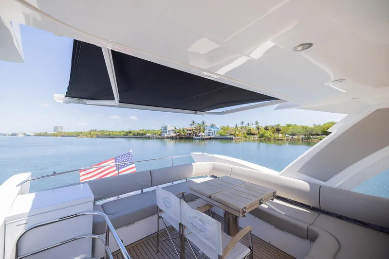 Sea Zar Yacht Photos Pics 2019 Sunseeker Manhattan 66 yacht with outdoor seating and scenic water view.