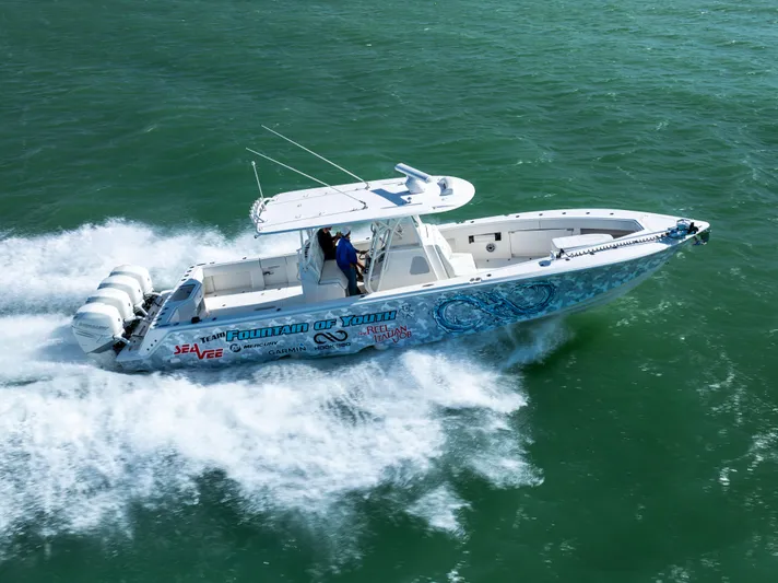  Yacht Photos Pics 2022 SeaVee 390Z boat speeding on open water, featuring vibrant graphics and triple outboard engines.