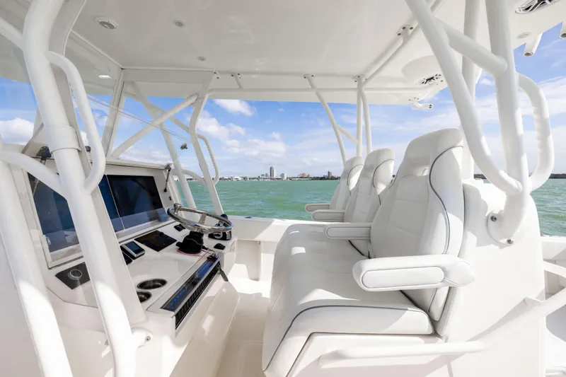  Yacht Photos Pics 2022 SeaVee 390Z boat interior with helm and seating, overlooking ocean and city skyline.