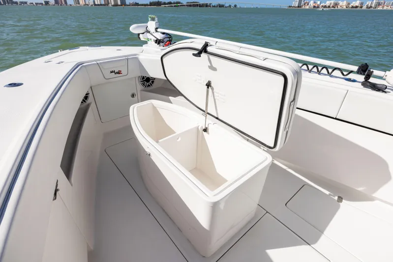  Yacht Photos Pics 2022 SeaVee 390Z boat with open storage compartment on deck, near water.